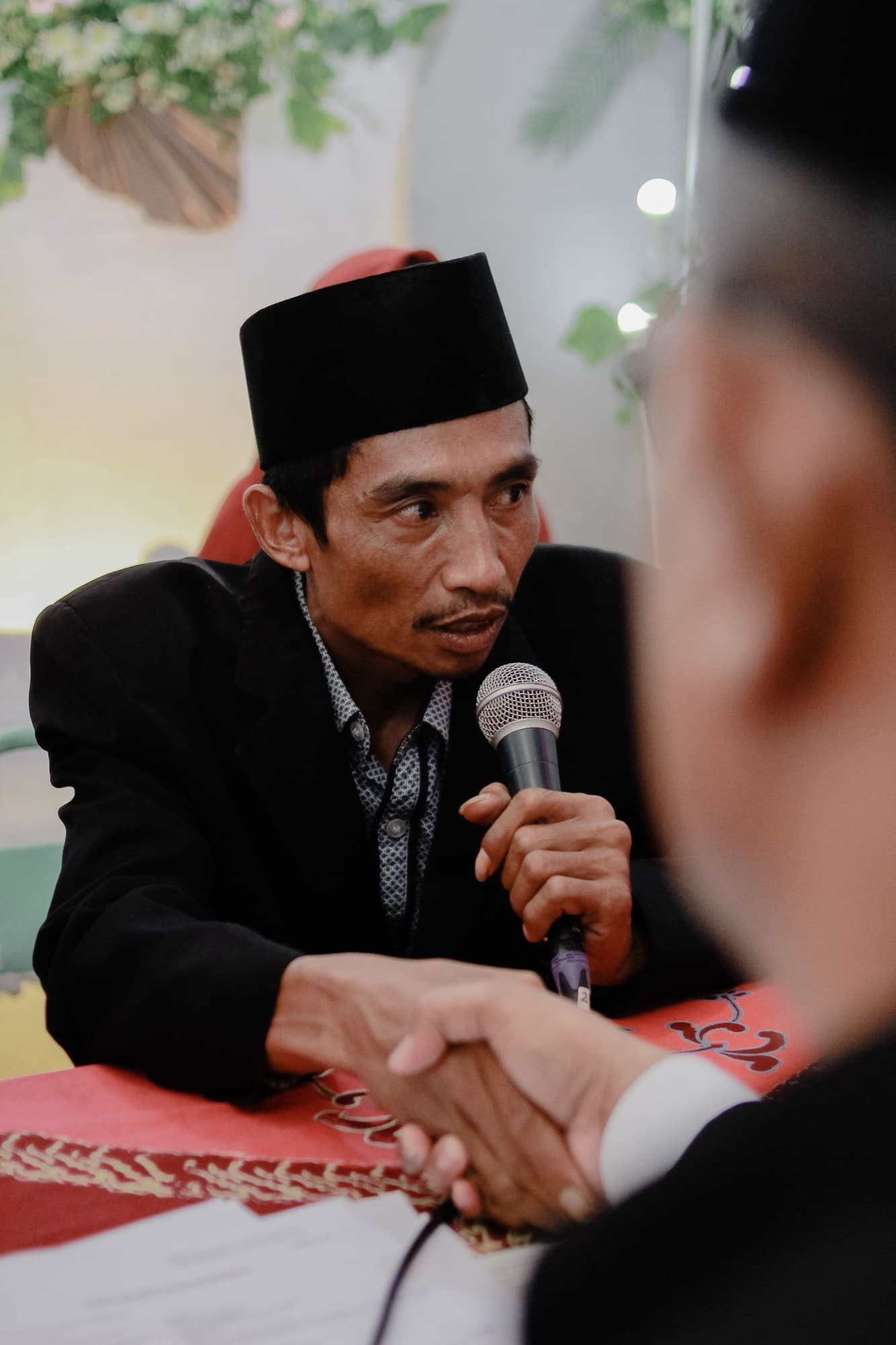 Wali mengucapkan ijab dengan berjabat tangan disaksikan penghulu