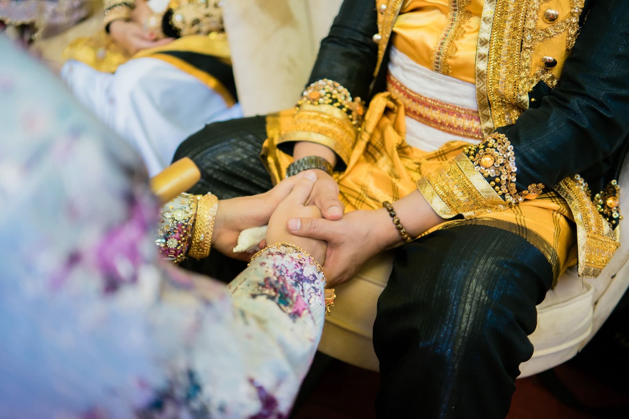 Genggaman tangan kedua mempelai berbusana adat pada prosesi akad nikah