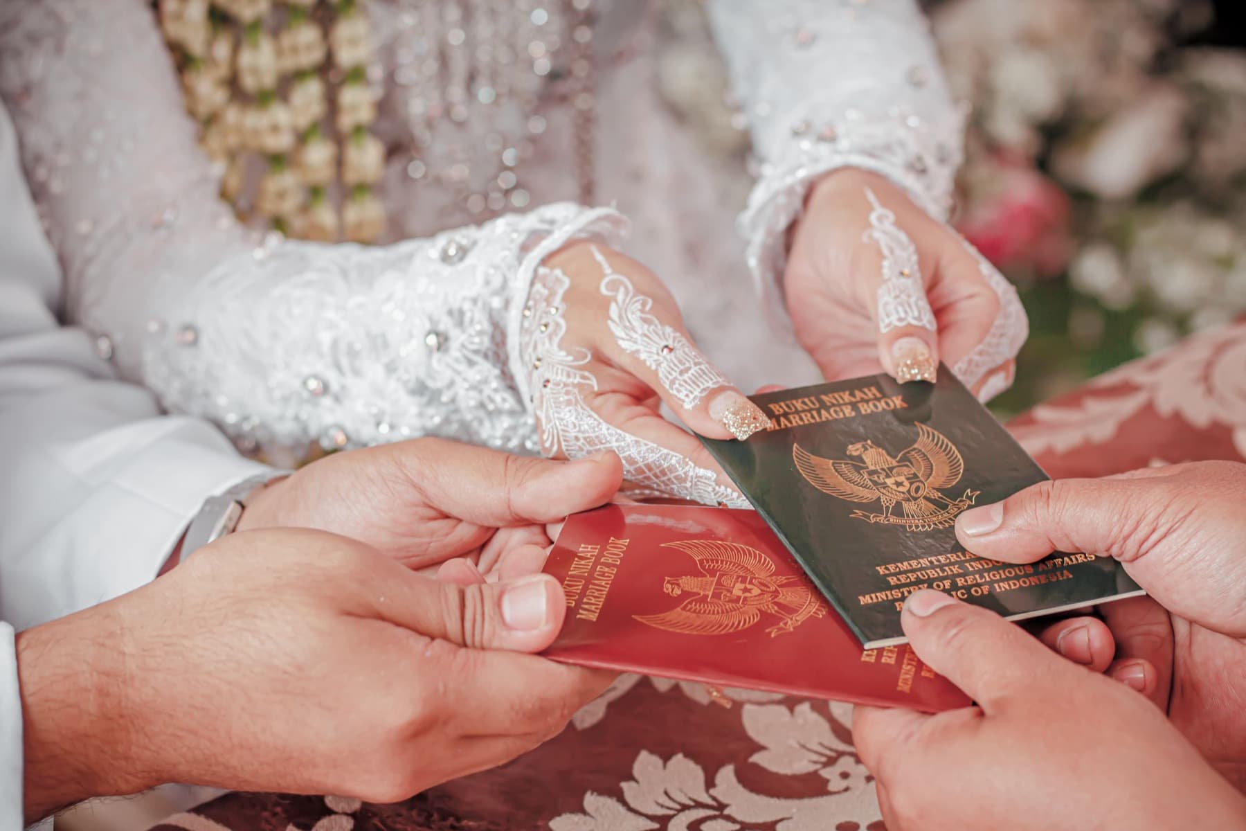 Petugas KUA menyerahkan dua buku nikah kepada pengantin